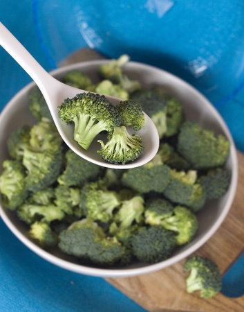 Broccoli in a white plate on a blue backgroundの写真素材