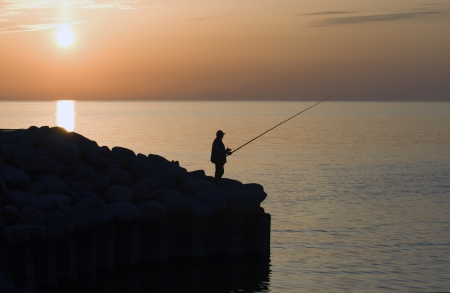 Fisherman silhouette at sunset  の写真素材