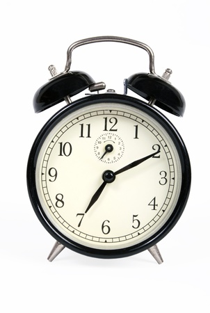 A classic old black alarm clock on white background の写真素材