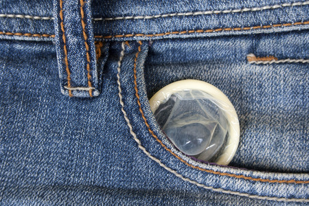 Condom peeking out from jeans pocketの写真素材
