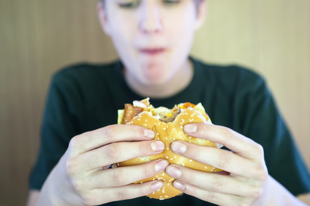 Boy eats a hamburgerの写真素材