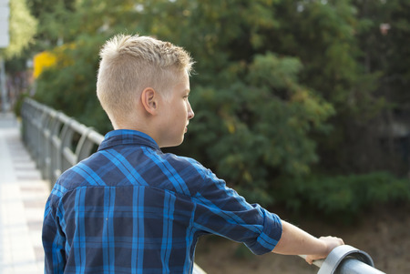 Boy's portrait in a blue shirt on the bridgeの写真素材