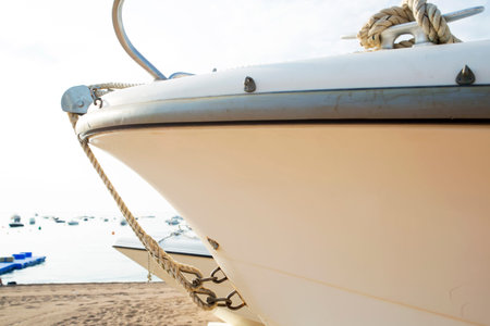 Fragment of motor boat on the empty sand shore sunny day.
