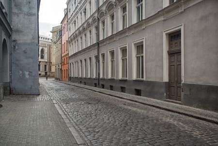 Narrow medieval street in old town of Riga city, Latvia. Walking through medieval streets of old Riga, tourists can find unique architectural ensembles and ancient houses.の写真素材