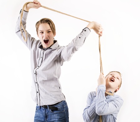 Young boy chocking another boy with a rope isolated on white background.の写真素材