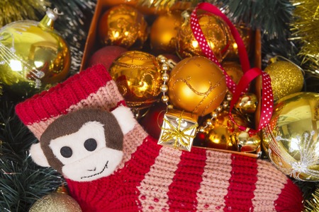 Any nice golden and red christmas balls with monkey, next year symbol on red sock like a christmas background.の写真素材