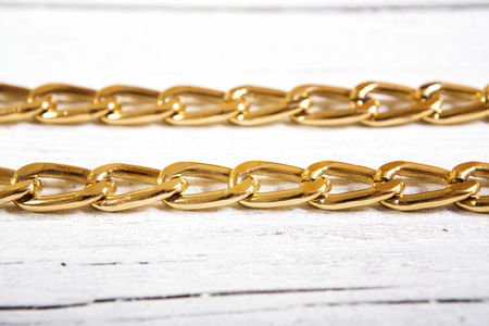 Brilliant gold baubles  like christmas decoration. Yellow heart  isolated on white wooden background.の写真素材