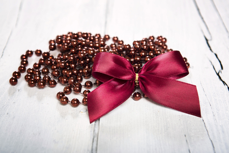 Christmas decoration. Red ball and  bow on white wooden background.の写真素材
