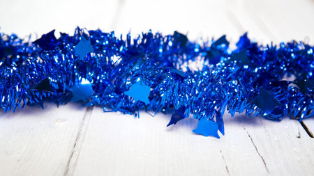 Christmas decoration. Blue garland on white wooden background.の写真素材