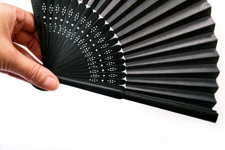Japanese stylish black fan is isolated on a white backgroundの写真素材