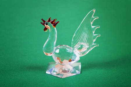 Figure of a glass rooster a symbol of 2017 on a green backgroundの写真素材