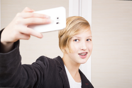 Teenager with phone. Poses for a selfie.の写真素材
