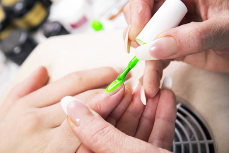 Manicure specialist care by finger nail in beauty salon.の写真素材