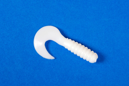 Fishing lure isolated on blue. Yellow and white colors.の写真素材