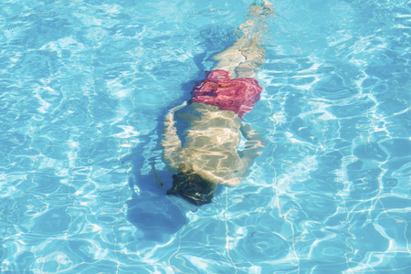 Person floats under water in the pool  の写真素材