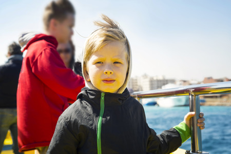 Portrait of the serious little boy onboard the shipの写真素材