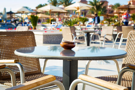 Empty table with chairs at restaurant outside in hotelの写真素材