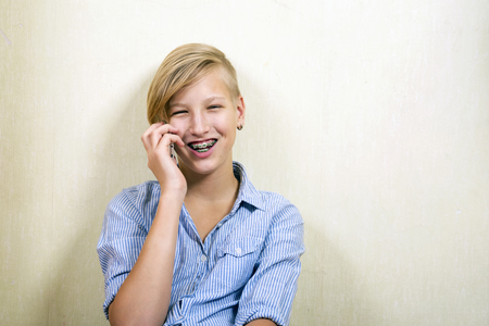 Teen with phone in hands. Conversation on the smartphone, modern communications.Orthodontics and bite correction.の写真素材