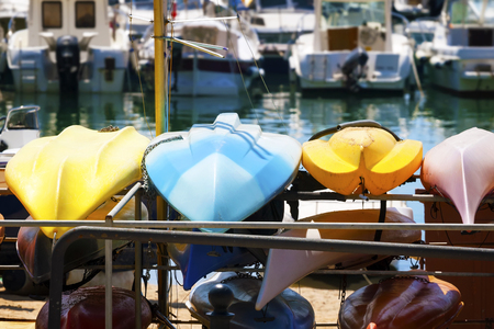 Plastic color boats dry on the background of boats and yachts  の写真素材