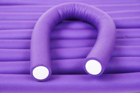 Violet hair curlers background. Tools for care of hairの写真素材