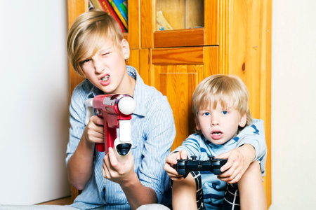 Brothers playing a computer games in their room