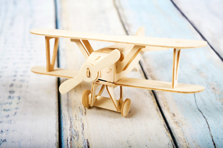 Wooden airplane model isolated on white wooden backgroundの写真素材