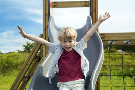 Happy little boy on the playground at the day timeの写真素材