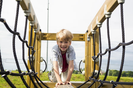 Happy little boy on the playground at the day timeの写真素材