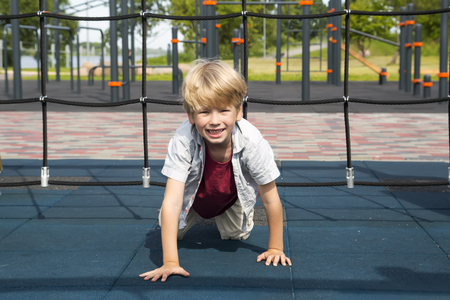 Happy little boy on the playground at the day timeの写真素材
