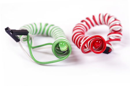 Red and green diodes on helical conductors are isolated on whiteの写真素材