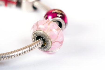Silver charm bracelet with pink beads isolated on white backgroundの写真素材