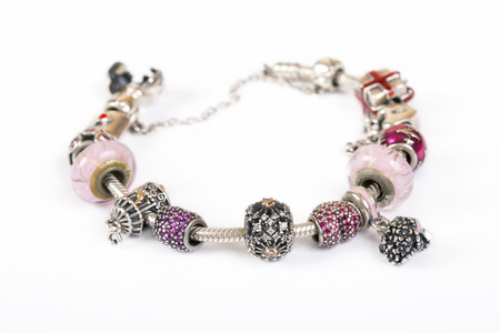 Silver charm bracelet with pink beads isolated on white backgroundの写真素材