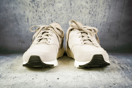 Pair of men's sports shoes on a concrete backgroundの写真素材