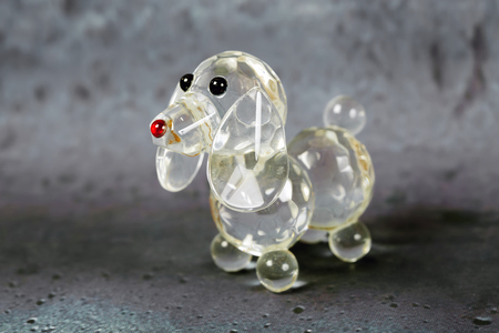 Close up glass souvenir figurine of dog on gray backgroundの写真素材