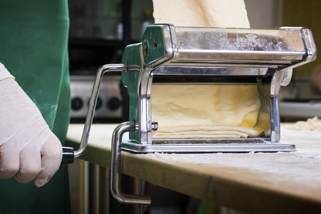 Process of production of  pasta. Fresh pasta and pasta machine on kitchen tableの写真素材