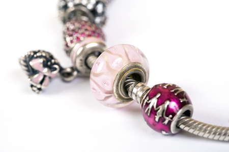 Silver charm bracelet with pink beads isolated on white backgroundの写真素材