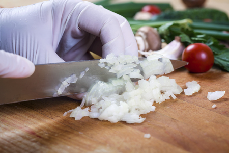 Woman chopping garlic on wooden board for cookingの写真素材