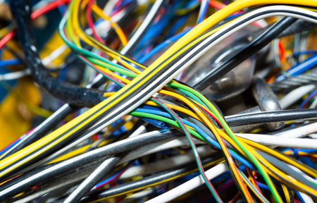 The bunch of electric wires or cables are strongly tangled together.