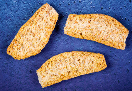 crackers with pieces and crumbs on blue background. Drycracker cookies with fiber and dry spices