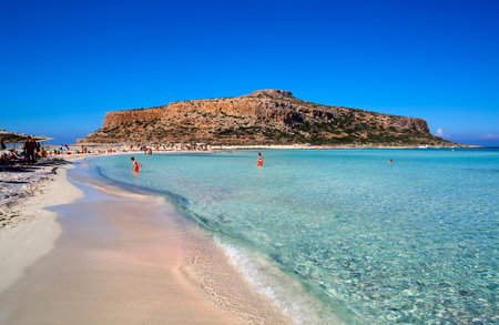 Balos lagoon on Crete island, Greece. Tourists relax in crystal clear water of Balos beach.