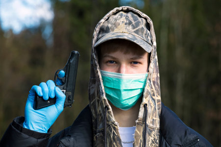 Man in protective sterile medical mask on his face looking at camera outdoors. Air pollution, virus,...