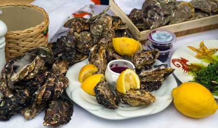 Fresh organic raw oysters with lemons on on traditional and natural wayr of a street market on a...