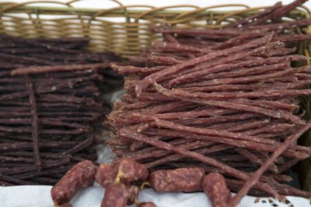 Traditional Lithuanian cured smoked sausage in wicker baskets on the counter of a street market on a fair of traditional products, in Klaipeda, Lithuaniaの写真素材