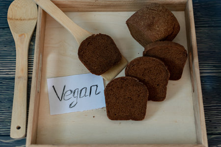 Sliced rye bread in a wooden box on a wooden backgroundの写真素材