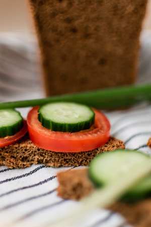 cucumber and tomato on rye bread with green onion, vertical