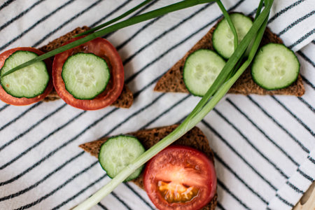 Sandwiches with cucumber and tomato on a striped tableclothの写真素材