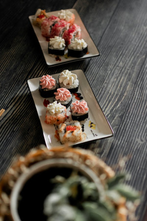 Sushi rolls on a black wooden background. Sushi rolls with cream cheese, salmon, caviar, caviar, caviar, nori, caviar. Sushi menuの写真素材