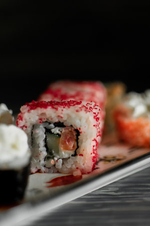 Sushi roll with salmon, cream cheese and cucumber on black backgroundの写真素材