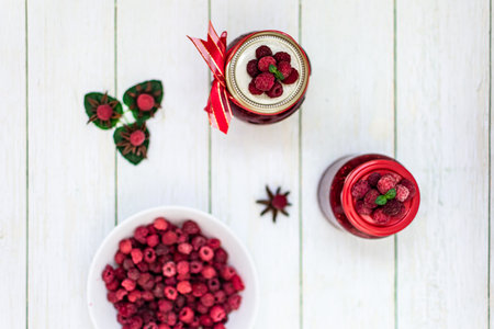 Homemade Raspberry Jam with Fresh Raspberries on a White Wooden Backgroundの写真素材
