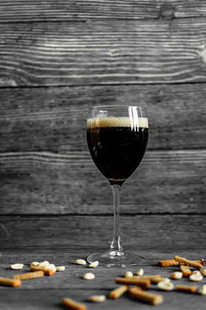 Glass of dark beer with croutons on rustic wooden backgroundの写真素材
